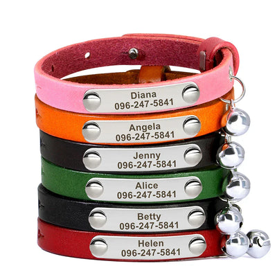 Stack of personalized leather pet collars with engraved name and phone number, each featuring a small bell and adjustable strap in various colors.